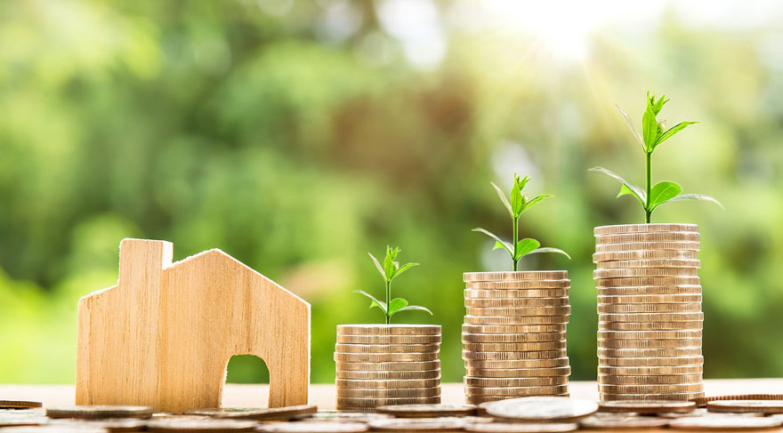 Bild: Haus als Investition,Holzhaus mit Geldmünzen