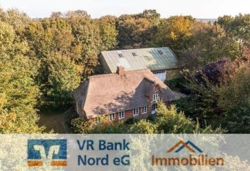 Denkmalgeschütztes Bauernhaus unter Reet mit Scheune auf einer Warft im Gotteskoog