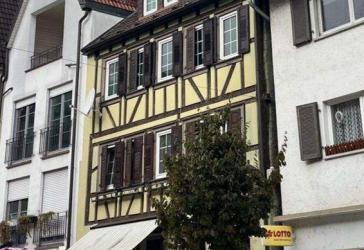 historisches Wohn- und Geschäftshaus in der Tauberbischofsheimer Fußgängerzone mit Parkplatz