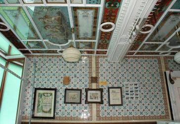 Historischer Laden mit originalen Jugendstil-/Gründerzeitfliesen und Stuckdecke – ideal für Boutique, Studio oder Praxis.