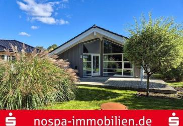 Bungalow im dänischen Stil mit offenem Wohnbereich und Carport mit Abstellraum.