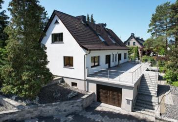 Eine Doppelhaushälfte mit einem großen Garten und Gartenhaus.